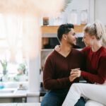 Una pareja joven y atractiva en su casa. Están abrazados y sonrientes. Felices de haber aplicado el Feng Shui en su hogar.