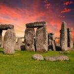 Stonehenge en un atardecer. El cielo está con los colores de la puesta de sol, creando un ambiente mágico y señalando este punto energético de la Tierra.